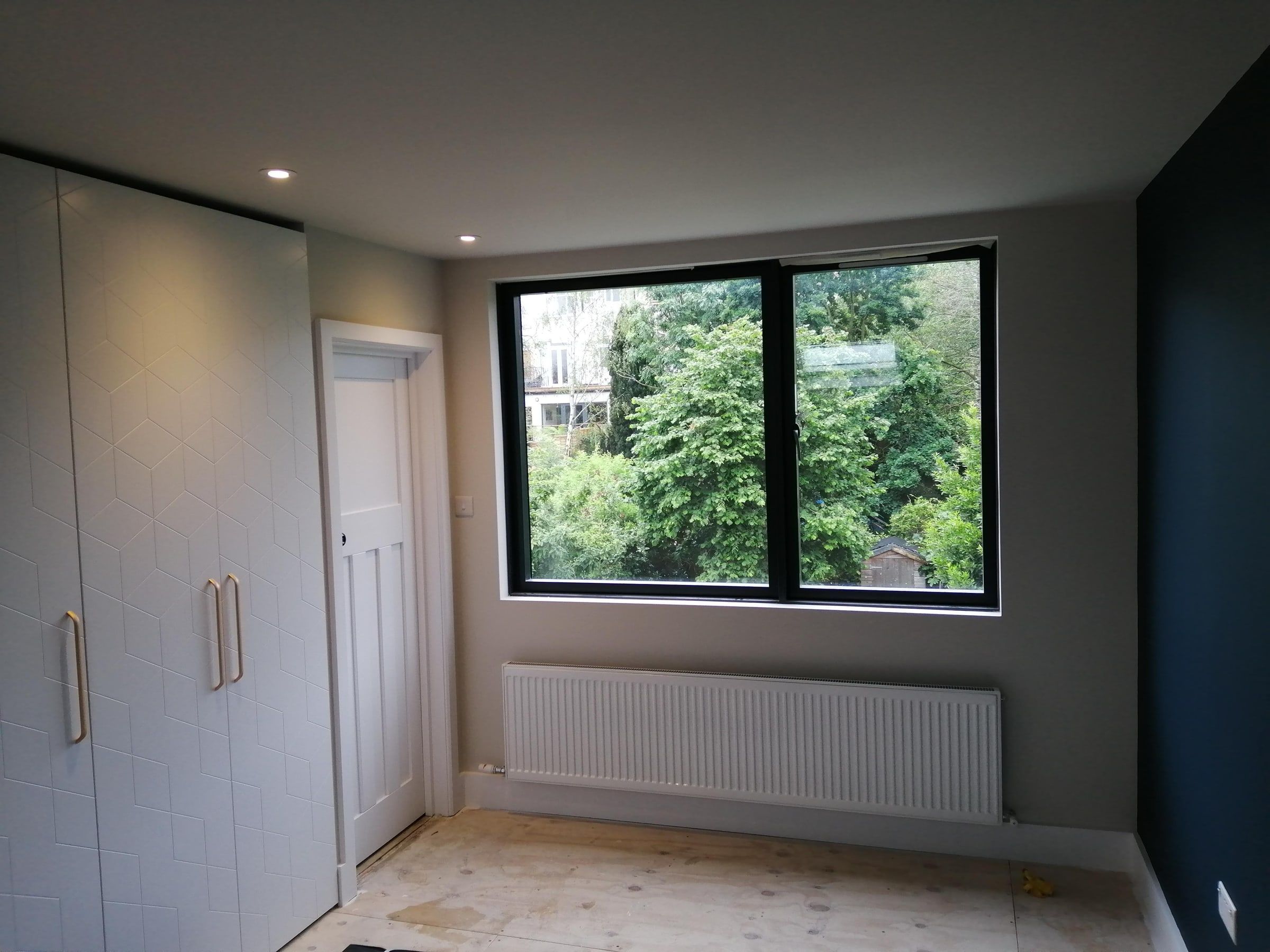 Loft bedroom with fitted wardrobes and a large dormer window